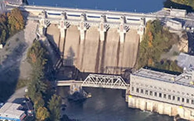 Aerial view of a hydroelectric dam spanning a wide river.